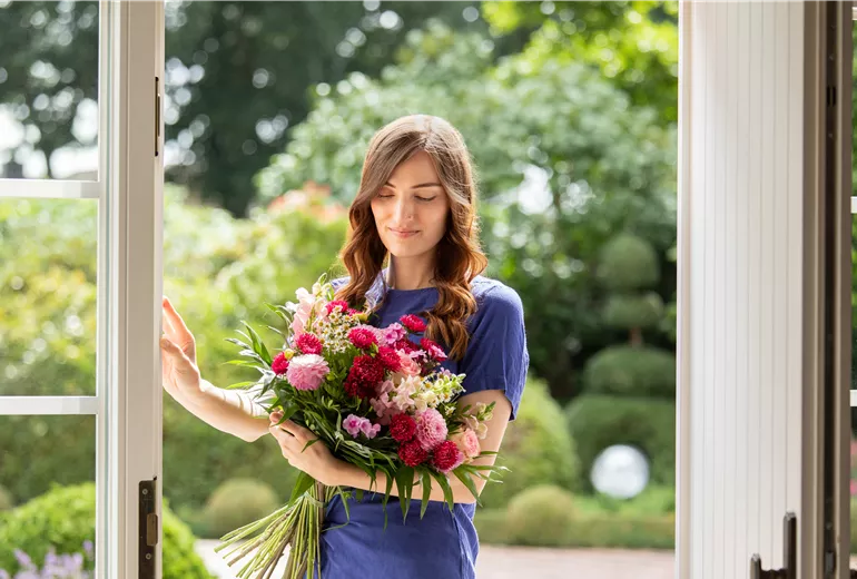 Lieferservice - Frau erhält Blumenpräsent